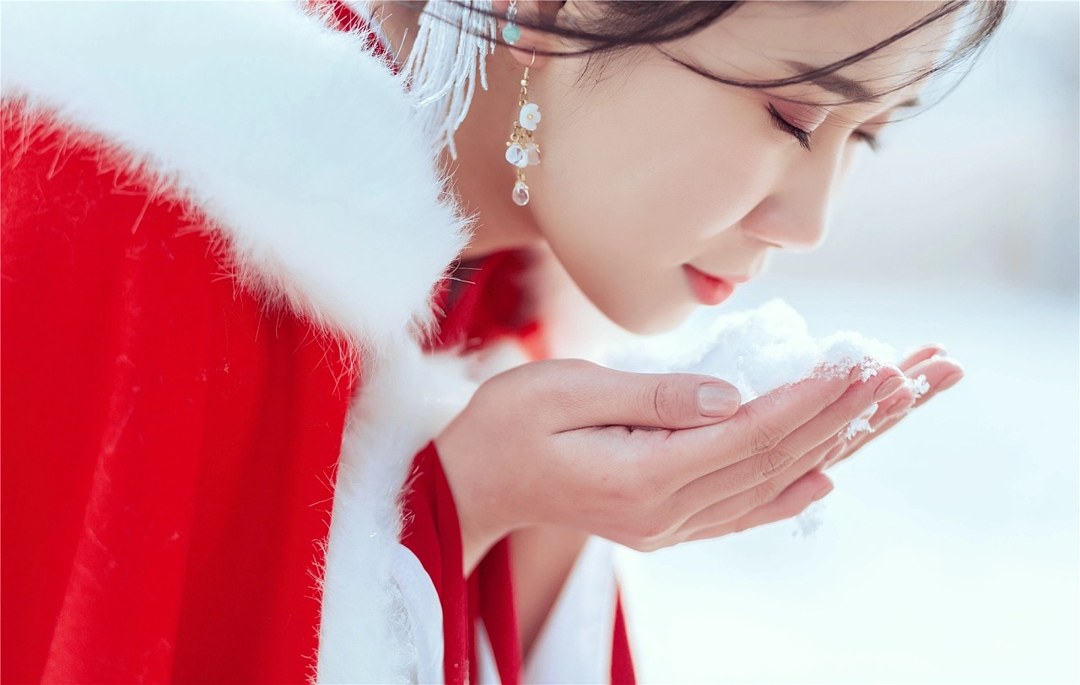 雪地红斗篷少女撑白伞，花簪垂珠与毛绒镶边清冷出镜