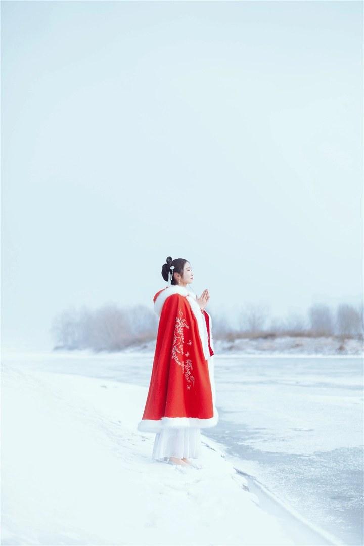 雪地红斗篷少女撑白伞，花簪垂珠与毛绒镶边清冷出镜