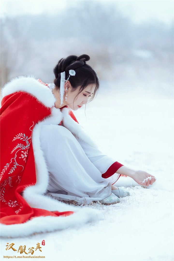 雪地红斗篷少女撑白伞，花簪垂珠与毛绒镶边清冷出镜
