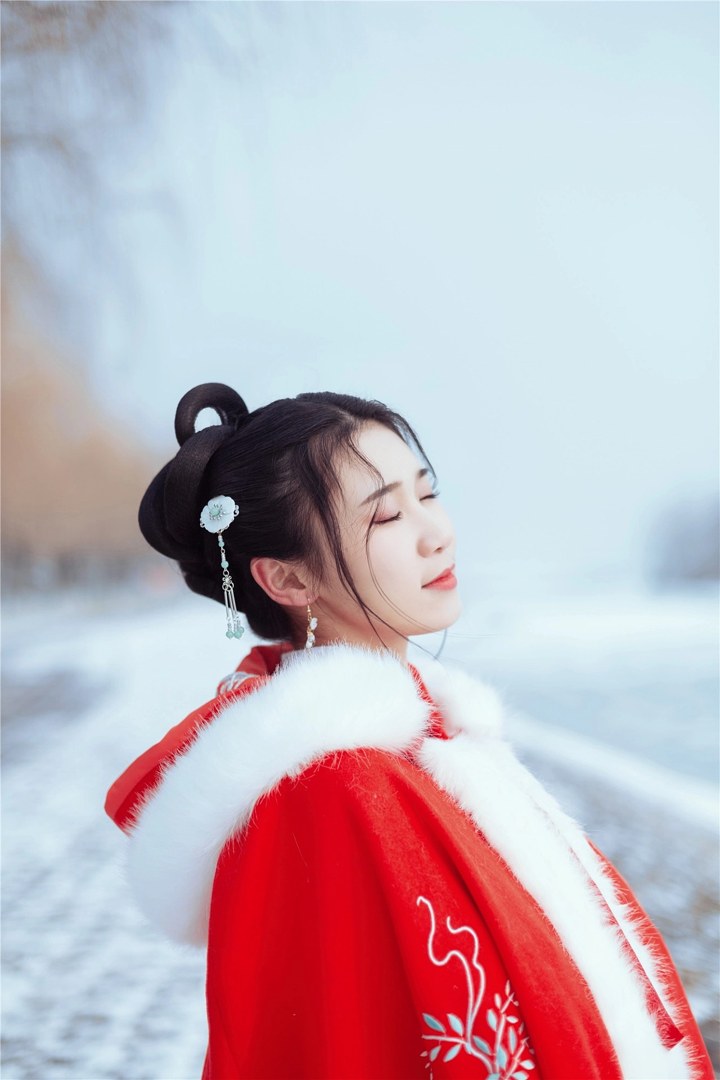 雪地红斗篷少女撑白伞，花簪垂珠与毛绒镶边清冷出镜
