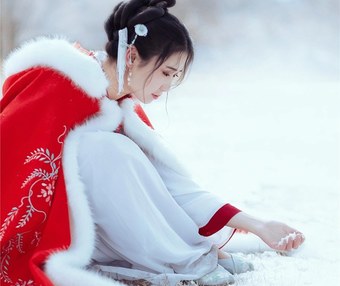 雪地红斗篷少女撑白伞,花簪垂珠与毛绒镶边清冷出镜